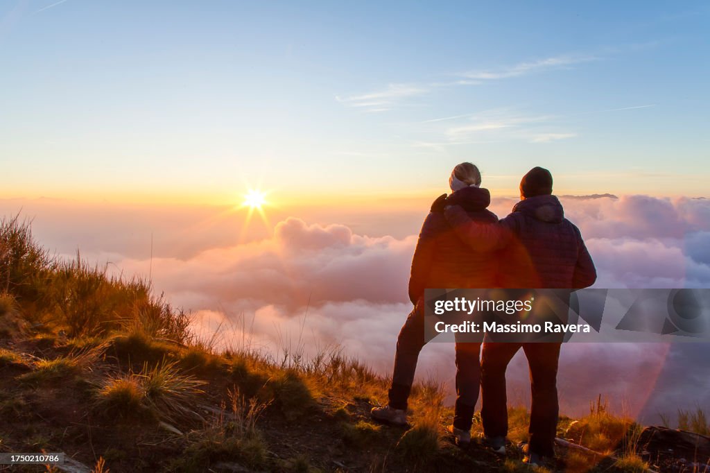 Couple admiring Autumn Sunrise over Italian Alps