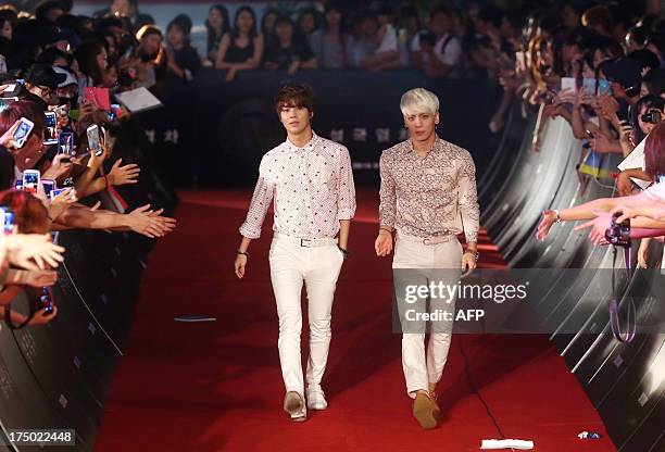 This photo taken on July 29, 2013 shows members of South Korean idol band "SHINee" arriving on the red carpet to attend the premiere of the film...