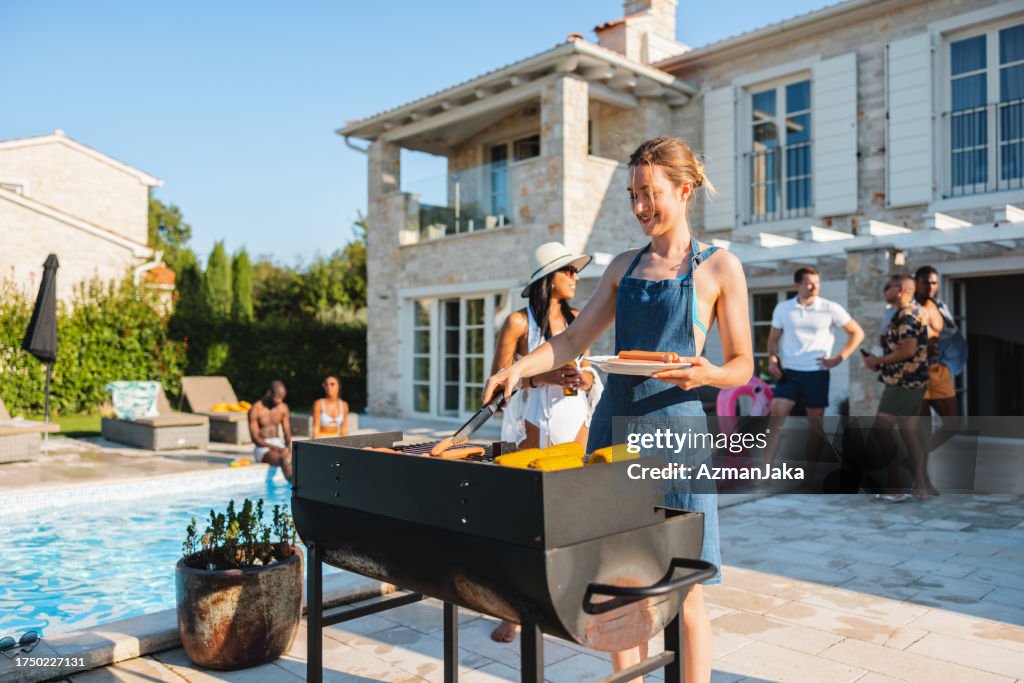 Alegre Mujer Caucásica Asando Salchichas En Una Parrilla De Barbacoa En Una Fiesta En La Piscina