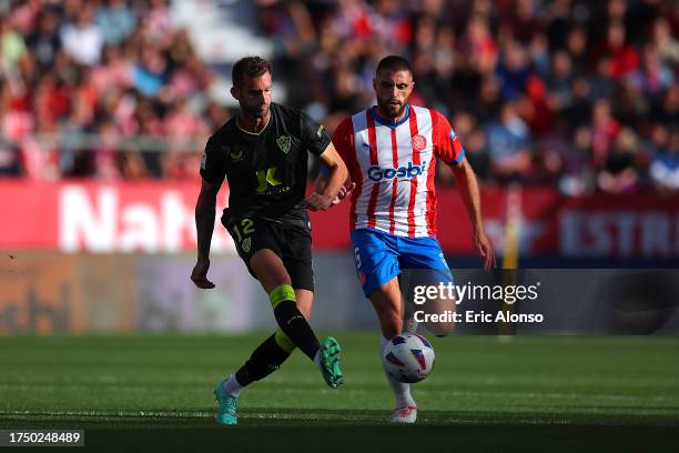 Leo Baptistao of UD Almeria makes a pass whilst under pressure from David Lopez of Girona FC during the LaLiga EA Sports match between Girona FC and...