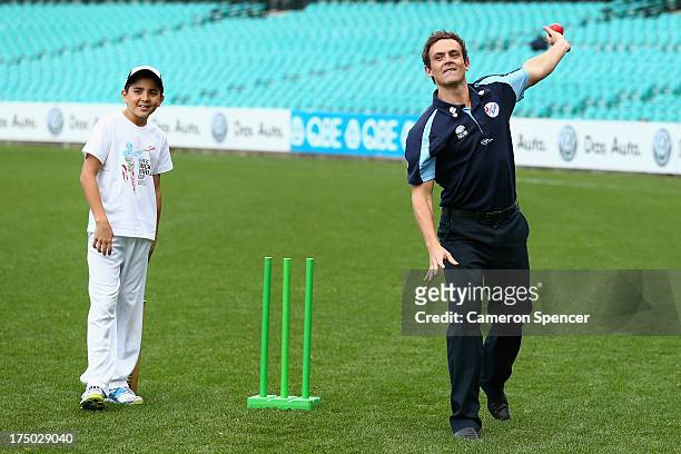 Australian cricket player, Steve O'Keefe bowls to young players during the announcement of the NSW venues for the 2015 ICC Cricket World Cup at...