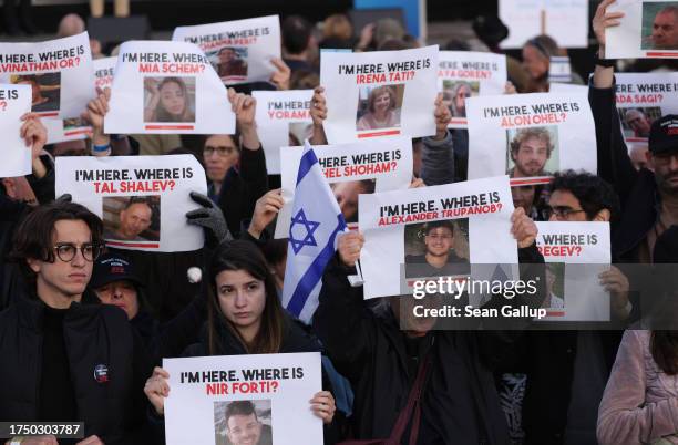 People attending a demonstration to show solidarity with Israel and against anti-semitism hold up photographs of hostages taken by Hamas on October...