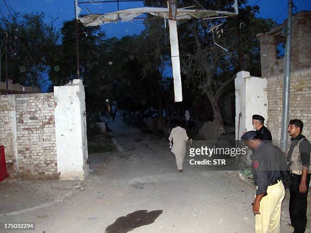 Pakistani policemen stand guard outside the Central Prison after an overnight armed Taliban militant attack in Dera Ismail Khan, in Khyber...