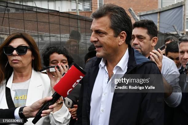 Presidential candidate for Union Por La Patria Sergio Massa arrives to the polling station as he talks to the media during the general elections at...