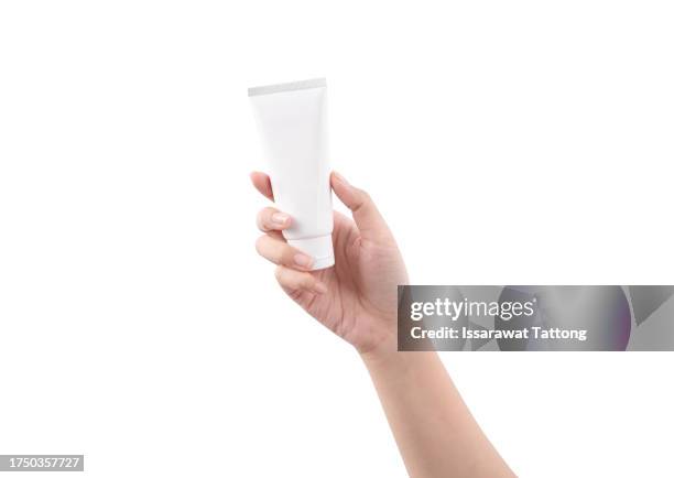 hand holding blank white plastic tube on white background. cosmetic beauty product branding mockup. copy space. high quality photo - creme tube ストックフォトと画像