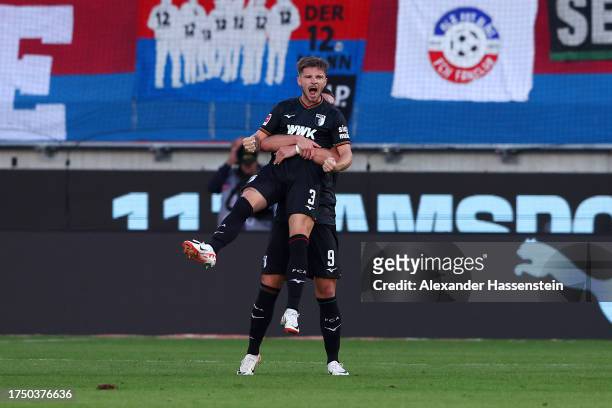 Mads Pedersen of FC Augsburg celebrates with Ermedin Demirovic of FC Augsburg after scoring the team's second goal during the Bundesliga match...