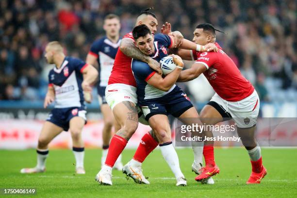 Victor Radley of England is tackled by Addin Fonua-Blake Silvia Havili of Tonga during the Autumn Test Series match between England and Tonga at John...