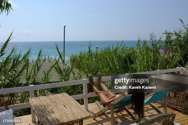 Lebanese woman enjoys the sun lying on a sun deck at Lazy B beach resort in a secluded surrounding 20 minutes outside the capital on July 21, 2013 in...