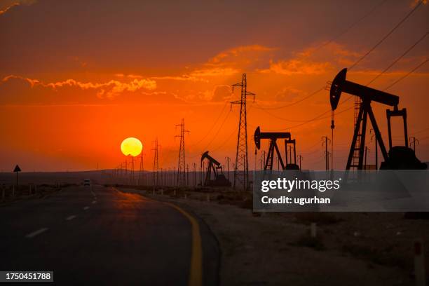 oil wells and power lines on the side of the highway. - resource stock pictures, royalty-free photos & images