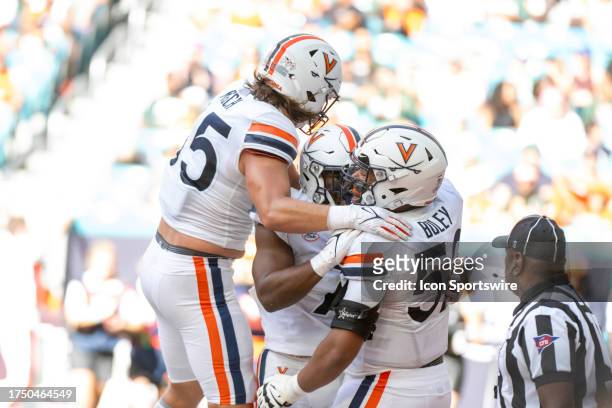 Virginia running back Mike Hollins celebrates scoring a touchdown with Virginia tight end Grant Misch and Virginia tackle McKale Boley during the...