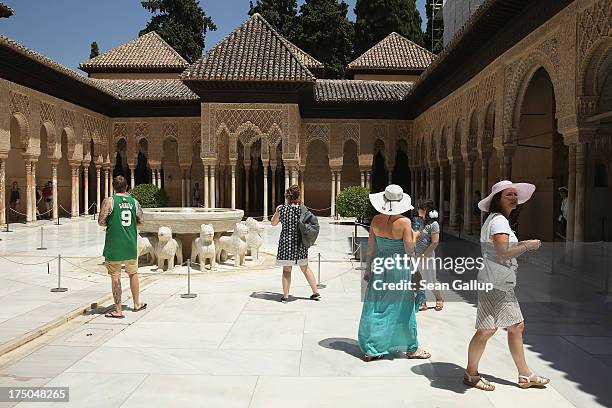 Visitors walk through the Patio of the Lions in the Nasrid Palaces at the Alhambra on July 23, 2013 in Granada, Spain. Southern Spain is among...