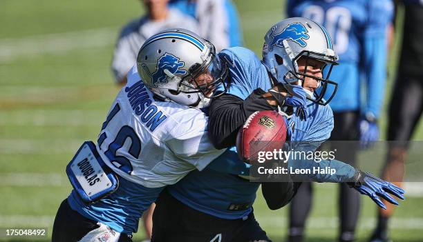 Domonique Johnson and Matt Willis of the Detroit Lions battle for the ball during training camp on July 30, 2013 in Allen Park, Michigan.