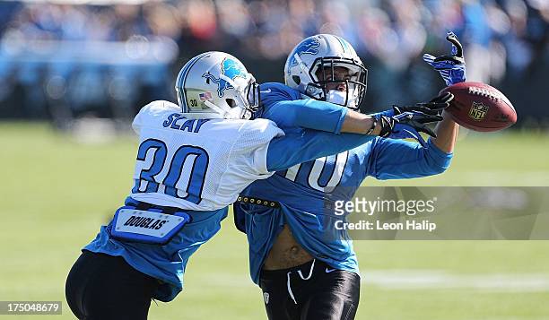 Darius Slay and Corey Fuller of the Detroit Lions battle for the ball during training camp on July 30, 2013 in Allen Park, Michigan.