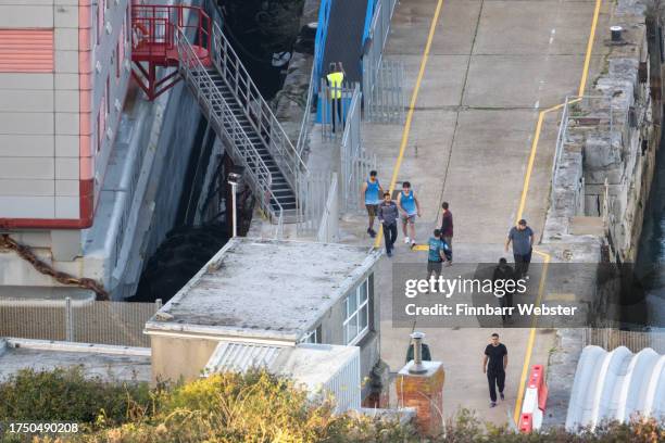 Asylum seekers and staff evacuate the Bibby Stockholm after an alarm sounds at Portland Port, on October 22, 2023 in Portland, England. The Home...