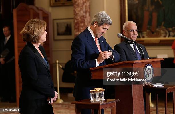 Secretary of State John Kerry checks his watch while appearing with Israeli Justice Minister Tzipi Livni and Palestinian chief negotiator Saeb Erekat...