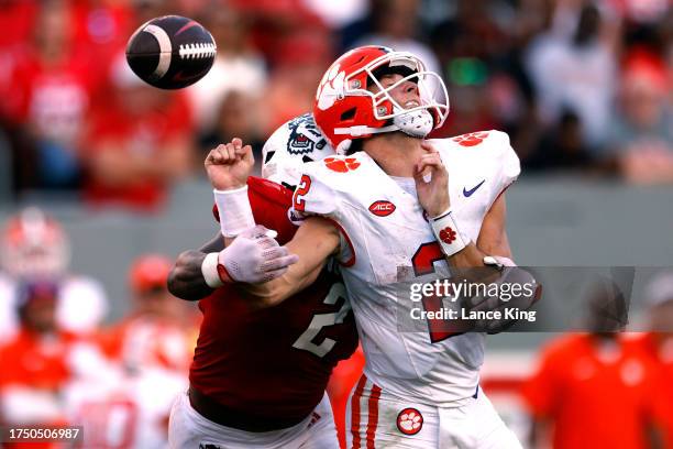 Cade Klubnik of the Clemson Tigers is hit by Jaylon Scott of the NC State Wolfpack during the second half of the game at Carter-Finley Stadium on...