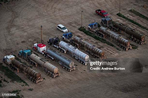 Tractor trailers at a salt-water treatment plant are seen in an aerial view in the early morning hours of July 30, 2013 near Watford City, North...