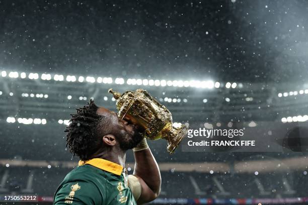 South Africa's flanker and captain Siya Kolisi kisses the Webb Ellis Cup as he celebrates winning the France 2023 Rugby World Cup final match against...