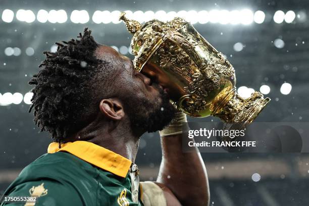 South Africa's flanker and captain Siya Kolisi kisses the Webb Ellis Cup as he celebrates winning the France 2023 Rugby World Cup final match against...