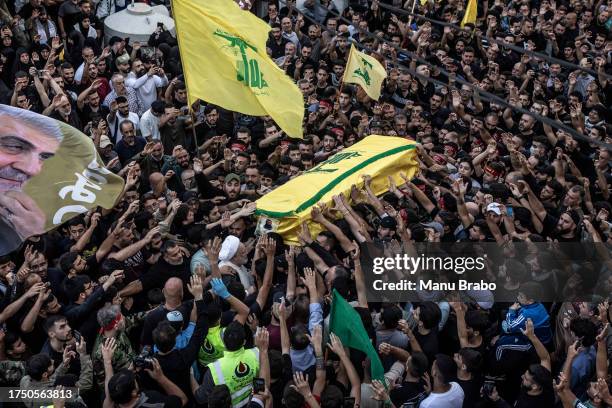 Hezbollah supporters carry the coffin of a Hezbollah militant killed by IDF while clashing yesterday in southern Lebanon yesterday, through the...