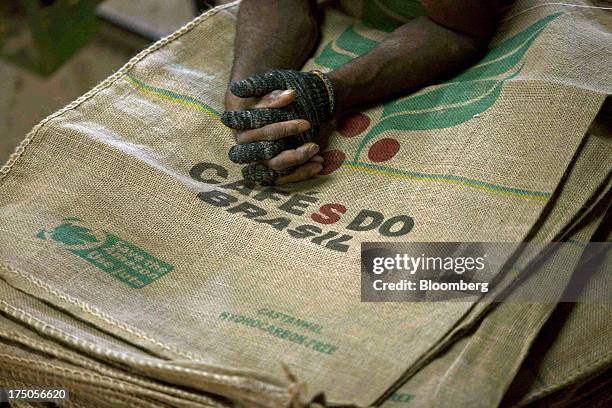 Worker takes a break on a pile of empty bags at the Japy grain house and silo complex belonging to the Cooxupe coffee cooperative in the Minas Gerais...