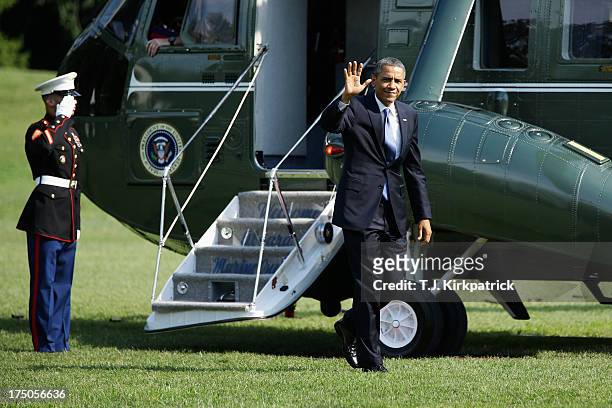 President Barack Obama waves to the press as he returns to the White House, after speaking at the Amazon Fulfilment Center in Tennessee, on July 30,...