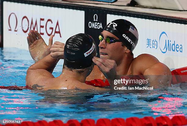 Matt Greave of USA is congratulated by his team mate David Plummer on his victory in the Men's 100m Backstroke Final at the Palau Sant Jordi on day...