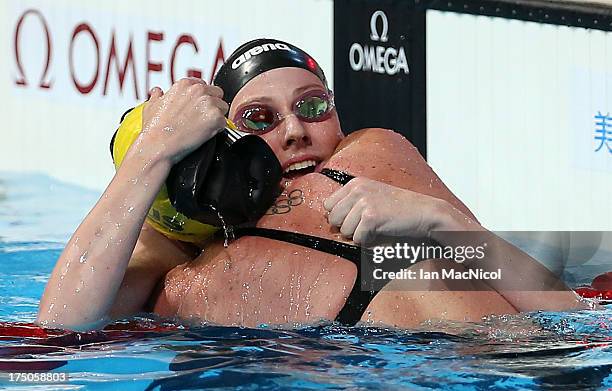 Emily Seebohm of Australia conrgatulates Missey Franklin of USA on winning the final of The Women's 100m Backstroke at the Palau Sant Jordi on day...