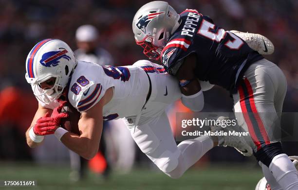 Dawson Knox of the Buffalo Bills is tackled with the ball by Jabrill Peppers of the New England Patriots in the third quarter of the game at Gillette...