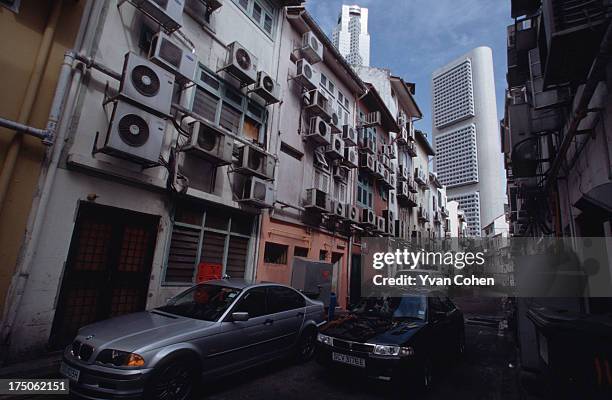 Mass of air conditioning units hang off the back side of a row of buildings that open onto the fashionable Boat Quay area. In Singapore's tropical...