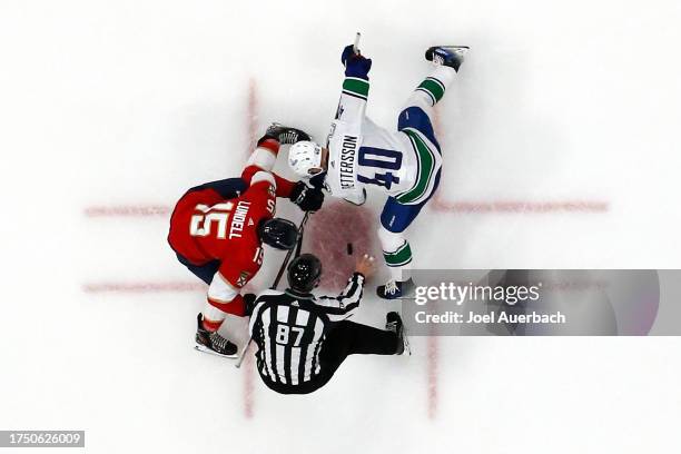 Linesman Devin Berg drops the puck between Anton Lundell of the Florida Panthers and Elias Pettersson of the Vancouver Canucks at the Amerant Bank...