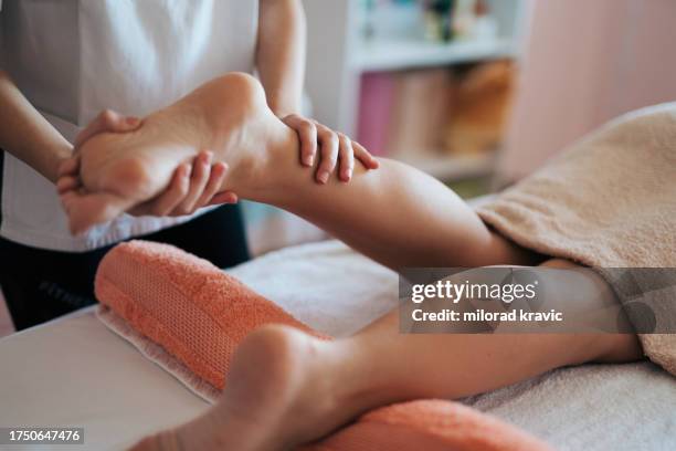 woman making massage in a beauty saloon. concept about spa, relaxation, body care and people. - massagebal stockfoto's en -beelden