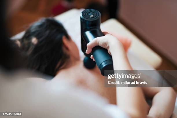 woman making massage in a beauty saloon. concept about spa, relaxation, body care and people. back massage. - massagebal stockfoto's en -beelden