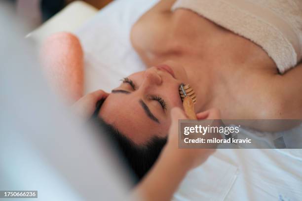 woman making massage in a beauty saloon. concept about spa, relaxation, body care and people. - massagebal stockfoto's en -beelden