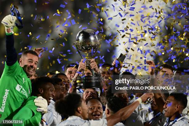 Liga de Quito players celebrate with the trophy of the Copa Sudamericana football tournament after the final match between Brazil's Fortaleza and...