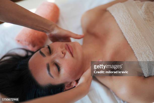 woman making massage in a beauty saloon. concept about spa, relaxation, body care and people. - massagebal stockfoto's en -beelden
