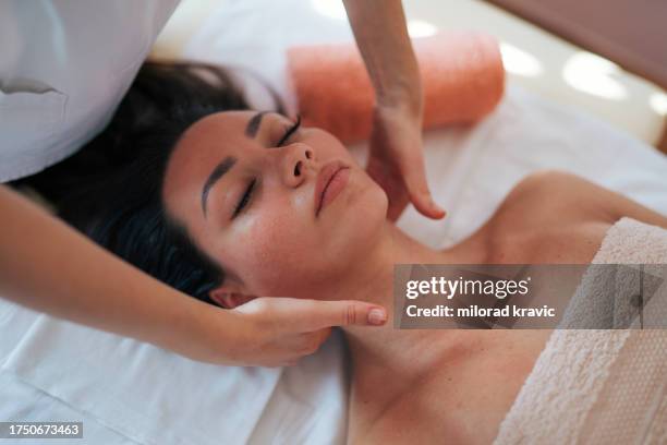 woman making massage in a beauty saloon. concept about spa, relaxation, body care and people. - massagebal stockfoto's en -beelden