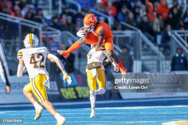 Running back Ashton Jeanty of the Boise State Broncos hurdles over corner back Jakorey Hawkins of the Wyoming Cowboys during the first half at...