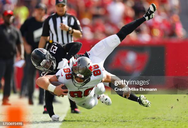 Cade Otton of the Tampa Bay Buccaneers is tackled by Richie Grant of the Atlanta Falcons in the fourth quarter of the game at Raymond James Stadium...