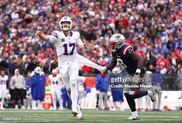 Ja’Whaun Bentley of the New England Patriots tugs at the jersey of Josh Allen of the Buffalo Bills as he throws the ball in the fourth quarter of the...