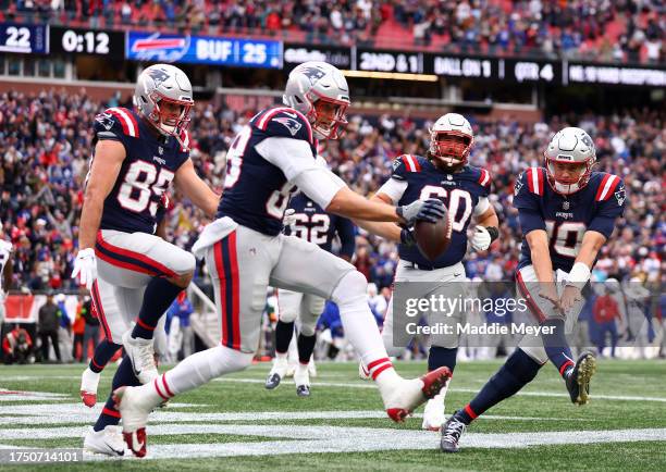 Mike Gesicki of the New England Patriots celebrates with Mac Jones after scoring a touchdown in the fourth quarter of the game against the Buffalo...