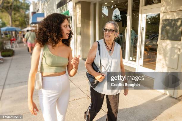 senior woman and adult granddaughter walking and talking in winter park florida - winter park florida stockfoto's en -beelden