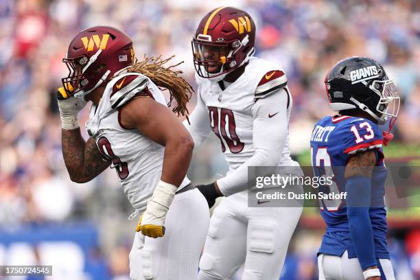 Chase Young and Montez Sweat of the Washington Commanders celebrate after a fumble recovery in the fourth quarter of the game against the New York...