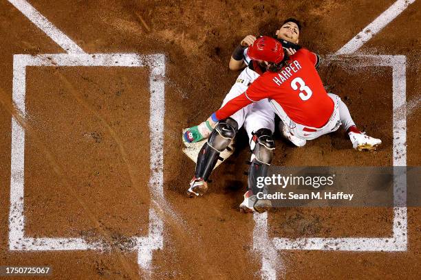 Bryce Harper of the Philadelphia Phillies checks on Gabriel Moreno of the Arizona Diamondbacks after colliding at home plate to score a run during...