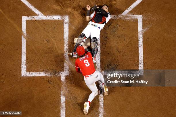 Bryce Harper of the Philadelphia Phillies checks on Gabriel Moreno of the Arizona Diamondbacks after colliding at home plate to score a run during...