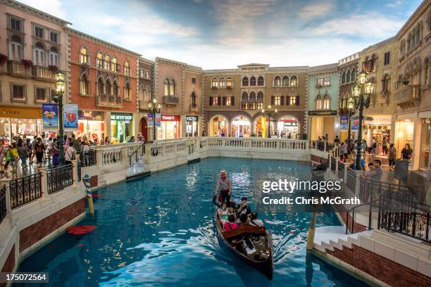 Tourists take a ride on a gondola up the man-made canal inside the Venetian Casino and Hotel on July 29, 2013 in Macau, Macau. Macau, the only place...