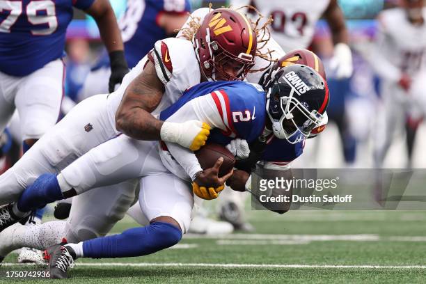 Montez Sweat and Chase Young of the Washington Commanders sack Tyrod Taylor of the New York Giants in the fourth quarter of the game at MetLife...