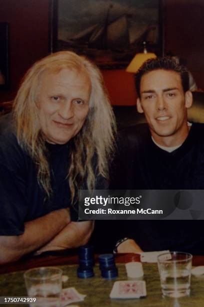 Joe Pytka and Jason Sehorn of the New York Giants sit at a table on the set of the ESPN "Dogs Playing Poker" television commercial with poker chips,...