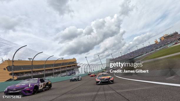 Martin Truex Jr., driver of the Bass Pro Shops Toyota, and Bubba Wallace, driver of the McDonald's Toyota, lead the field on a pace lap prior to the...