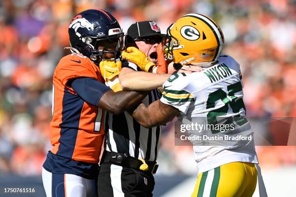 Referee attempts to break up a fight between Jerry Jeudy of the Denver Broncos and Keisean Nixon of the Green Bay Packers after a play in the first...